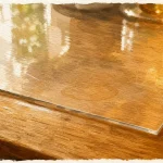 Protection table bois : plaque en verre transparent sur table en bois